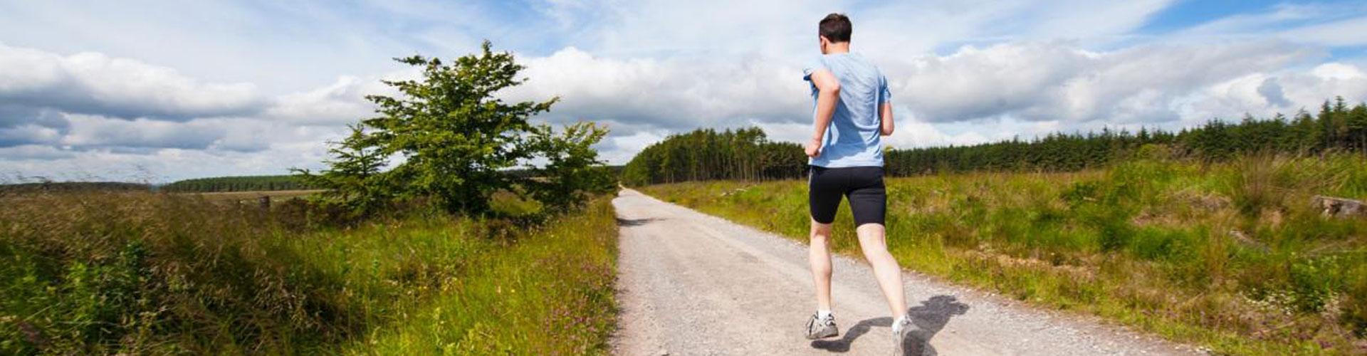 A Person Running Along a Dusty Track in the Open Countryside