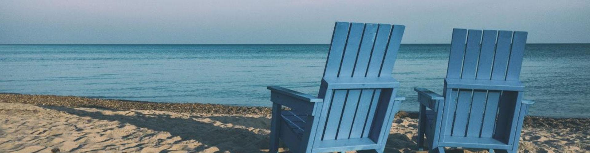 Two Wooden Chairs Looking out to sea